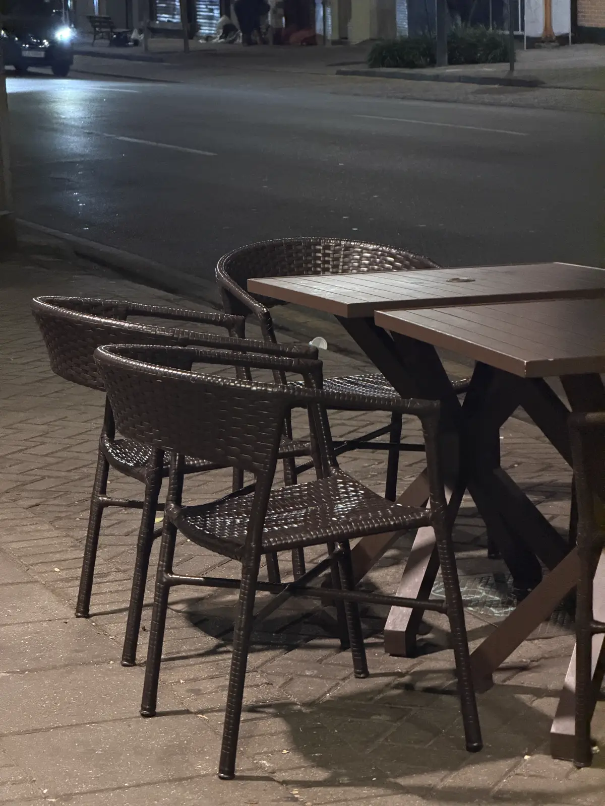 Mesas na calçada iluminadas à noite