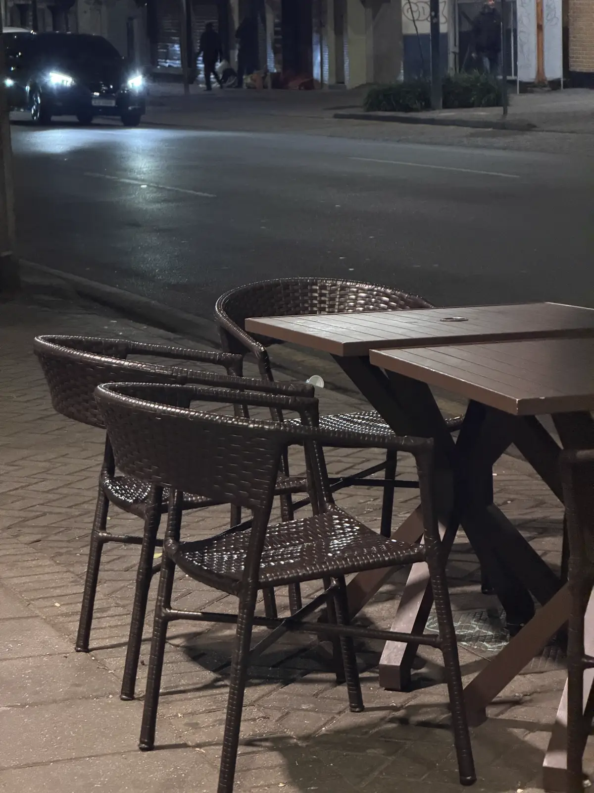 Mesas do pátio na calçada durante a noite